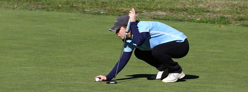 A female golfer lines up a putt during the 2018 State Finals.