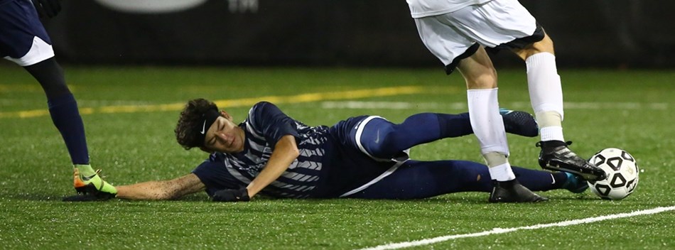 A Magruder player slide tackles a C.M. Wright player in the 2018 Class 4A Boys Soccer State Final.