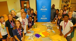 Students at the 2016 Student-Athlete Leadership Conference pausing their work around the table during their community service project.