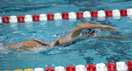 A female swimmer races freestyle during the 2019 State Swim Meets.