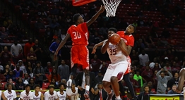Two male Edmondson basketball players try to block the shot of a Fairmont Heights player in the 2017 Class 1A State Finals.