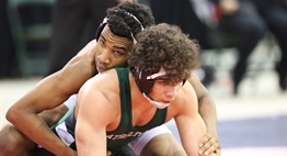 Two wrestlers get set on the mat to move on the officials' whistle at the 2018 State Tournament.