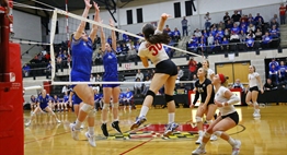Defenders attempt to block an opponent's spike at the net during the 2018 State Finals.