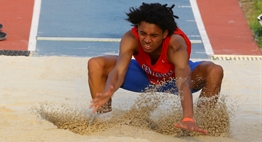 A male jumper hits the sand in the pit on his landing at the 2016 State Championship Meets.