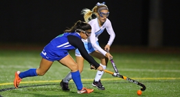 Two field hockey players battle for control of the ball during the 2016 State Finals.