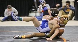 One wrestler tries to take down another while on the mat during a 2018 State Championship bout.