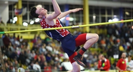 A male high jumper eyes the crossbar as he takes off during the 2019 State Championship Meet.