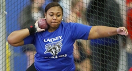 A female shotput athlete in mid-spin prior to releasing the shot during the 2018 State Championships.