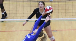 A setter arches her back while setting up the hitter behind her at the net during the 2017 State Tournament.