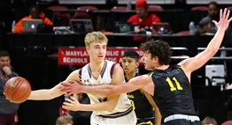 A male player reaches to defend against an opponent's pass at the 2019 Boys State Basketball Tournament.