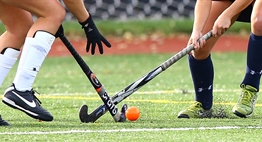 Two opposing field hockey players battle for a loose ball in the 2015 State Finals