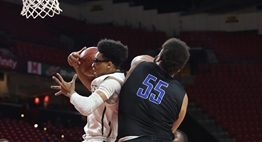 A Lake Clifton male basketball player snares a rebound in front of a North Caroline player in the 2018 State Finals