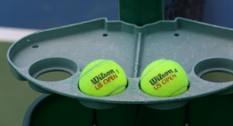 A courtside tray at the net holding Wilson tennis balls during the 2017 State Championships.