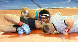 A wrestling official lies prone while assessing the possibility of a pin in a 2016 State 4AA/3A bout.