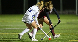 An attack player tries to dribble past a defender at the 2018 State Field Hockey Finals.
