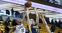 A female B-CC basketball player's shot is blocked from the side by a Catonsville defender in the 2018 State Tournament.