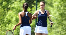 A female doubles team high fives one another after a point in the 2016 State Tennis Tournament.