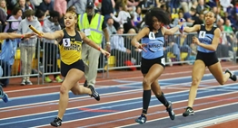 Female relay runners try to hand off their batons during the 2019 State Championships.