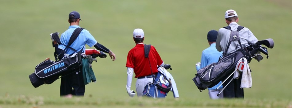 A foursome of male golfers walk off of the tee carrying their clubs during the 2018 State Finals.