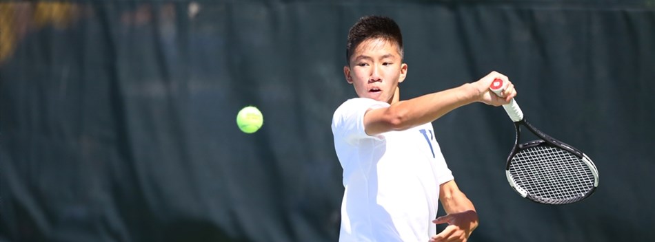 A male singles player backhands a return during the 2019 State Tennis Tournament.