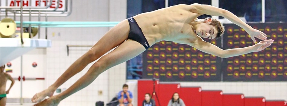 A male diver in the midst of a turn after taking off from the board at the 2019 State Championships.