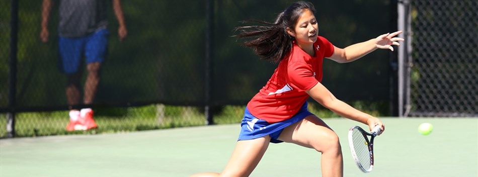 A female volleys the ball off of her racket at the 2019 State Tennis Tournament.