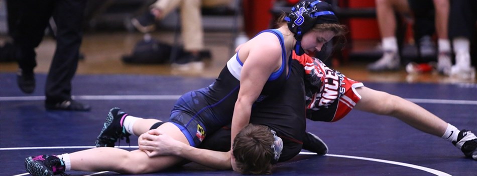 A female wrestler has the upper hand against a male wrestler during the 2019 Class 3A State Duals.