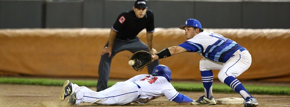 A baserunner dives back to the bag ahead of the throw at the 2019 Class 4A State Baseball Final.