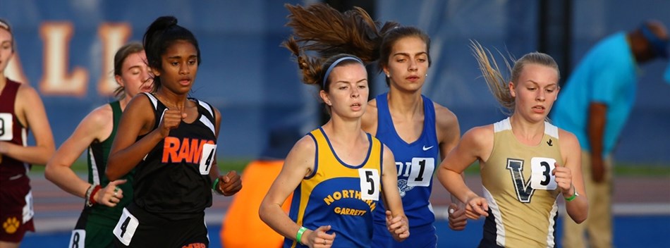 Female runners jockey for position during a long race at the 2019 State Track and Field Meets.