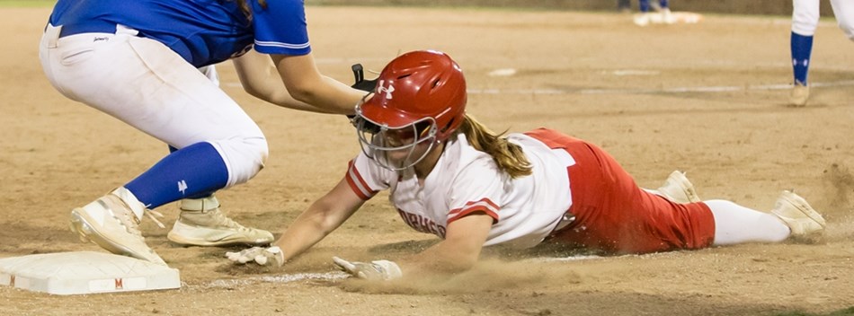 A runner dives head first back towards third base during the 2019 Class 4A State Softball Final.
