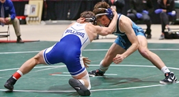 Two male wrestlers grapple for a takedown at the 2019 State Championships.